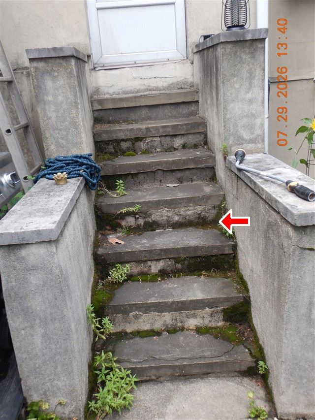 Inspection photograph of exterior concrete steps with spalled treads and open joints
