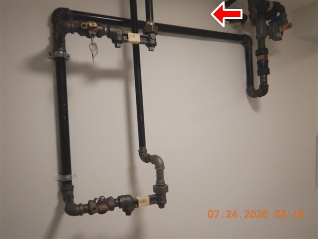 Inspection photograph of a black iron gas piping run