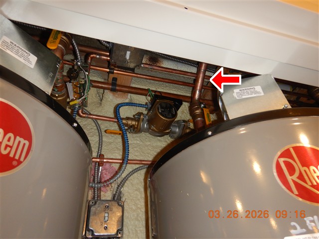 Copper supply pipework above a pair of domestic water heaters, photographed during an inspection.
