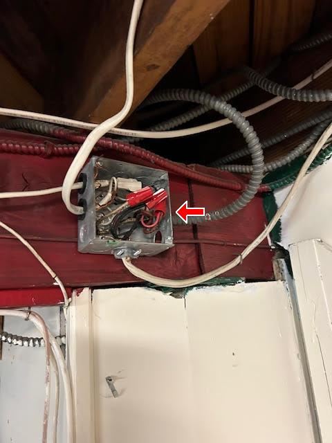 Inspection photograph of an open electrical junction box with conductors visible