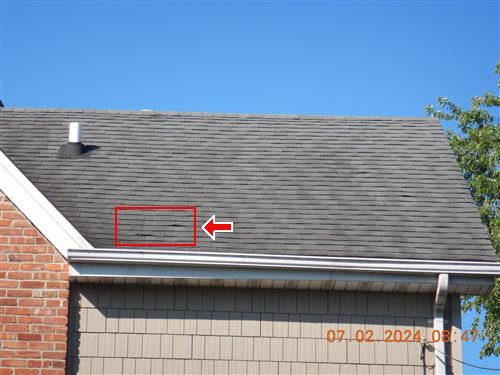 Inspection photograph of a roof slope with an area of concern outlined in red