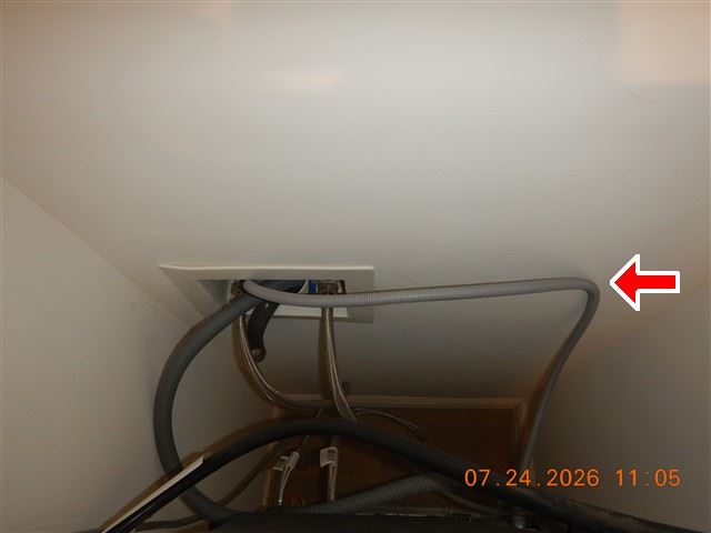 Inspection photograph of supply and waste connections under a kitchen sink