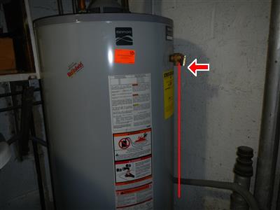 A domestic water heater with a vertical red marker line on the report photograph.