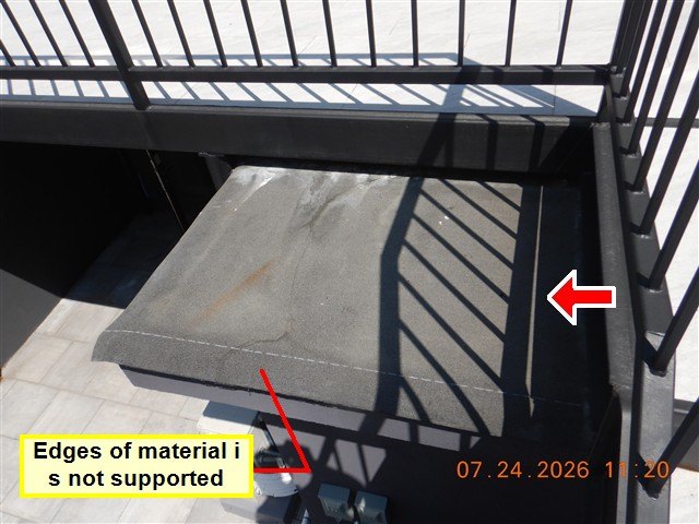 A paver on a rooftop deck beside an iron railing, labelled as having unsupported edges.