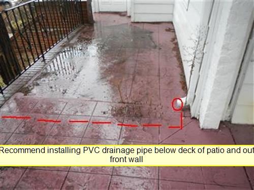Wet paved patio beside a house wall with a red circle and dashed red line marking where a leader pipe empties.