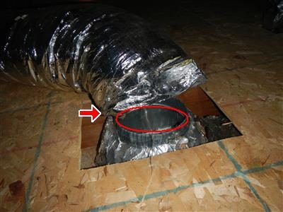 Attic floor with a flexible foil duct lying beside an open register boot, circled in red with a red arrow.