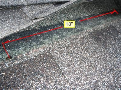 Lifted shingle on a garage roof with a red line and an 18 inch label marking the distance between nails.