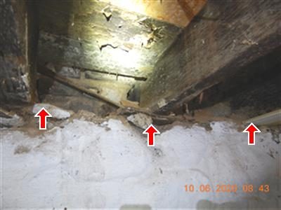 Ends of floor joists above a whitewashed foundation wall with a gap beneath them, marked with three red arrows.