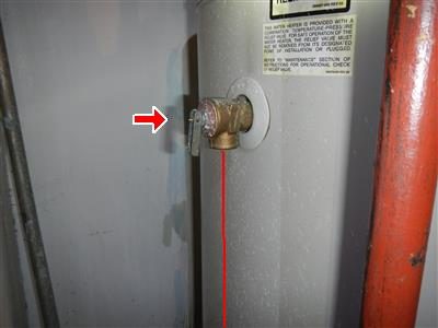Temperature and pressure relief valve on the side of a grey water heater with no discharge pipe, red arrow and line.
