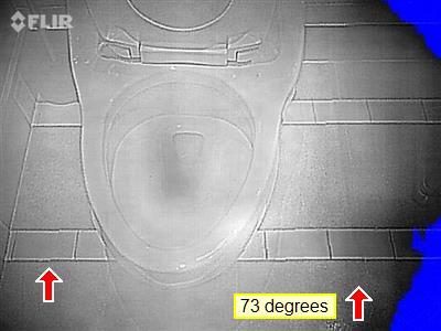 Infrared thermal image of a toilet and tiled floor with two red arrows and a 73 degrees label.