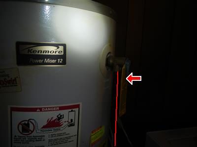 Side of a Kenmore water heater with the TPR valve outlet marked by a red arrow and a red line drawn downward.