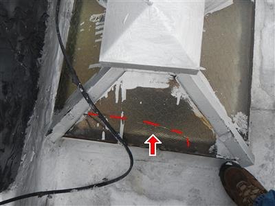 Pyramid-shaped skylight with wired glass on a roof, red dashed line and arrow on one panel.