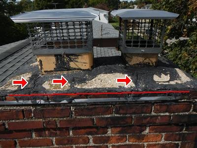 Brick chimney top with two metal flue caps, tarred crown, red arrows and red line markup