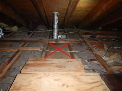 Attic floor with plywood and joists, one bay without insulation marked with a red X, a metal duct beyond.