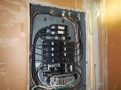 Open main breaker panel showing the main breaker, rows of branch breakers and wiring.