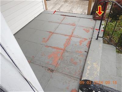 Painted porch floor and step with widespread peeling paint, yellow arrow and red marks