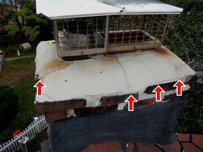 Chimney top with cracked concrete crown, rust staining, and four red arrows