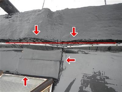 A silver-coated flat roof with seams and edges marked by red arrows.