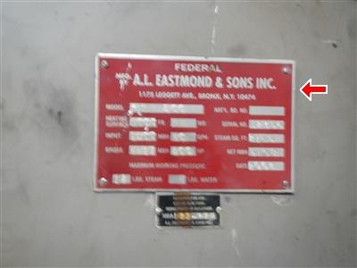 A red manufacturer's plate on a steel steam boiler, reading A.L. Eastmond and Sons Inc.