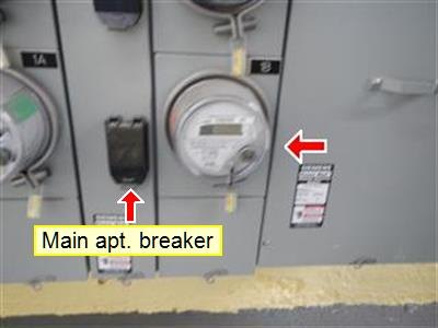 Electric meter bank with red arrows and a yellow label reading Main apt. breaker