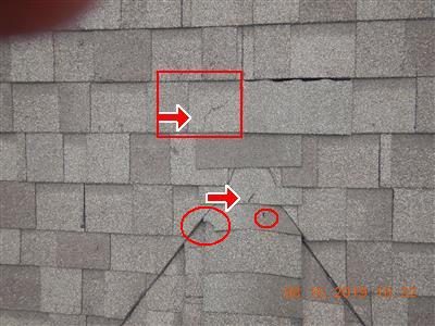 Grey asphalt shingles on a dormer with red arrows, a red box and red circles marking cracks and an exposed nail head.