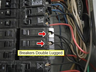 Close-up of circuit breakers with two red arrows at terminals; report label reads Breakers Double Lugged.