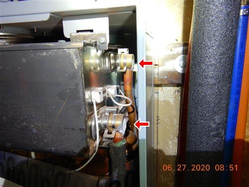 Copper and steel piping connections above a boiler, two findings arrowed.