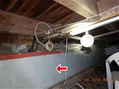 Bare metal ductwork running under floor joists in a crawl space, marked with a red arrow.