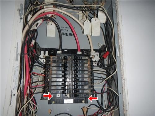 Open sub panel with rows of breakers and labelled conductors, two red arrows at the lower corners.