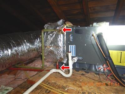 Attic air handler with foil-wrapped duct and white PVC condensate pipe, two red arrows