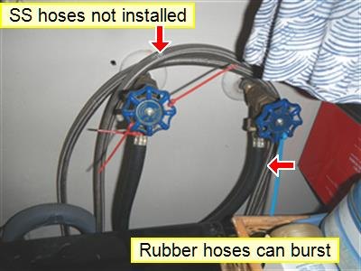 Two laundry shut-off valves with black rubber supply hoses and yellow labels about hose type
