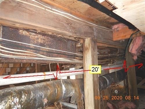 Crawl space view of a dark, deteriorated wood beam over a post with red lines and a 