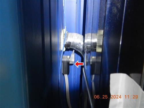 Stainless steel flexible dryer vent hose connected behind a dryer, marked with a red arrow.